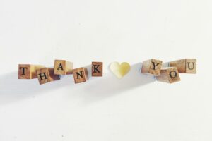 Decorative image: Thank you spelled out in black letters printed on individual wooden blocks.